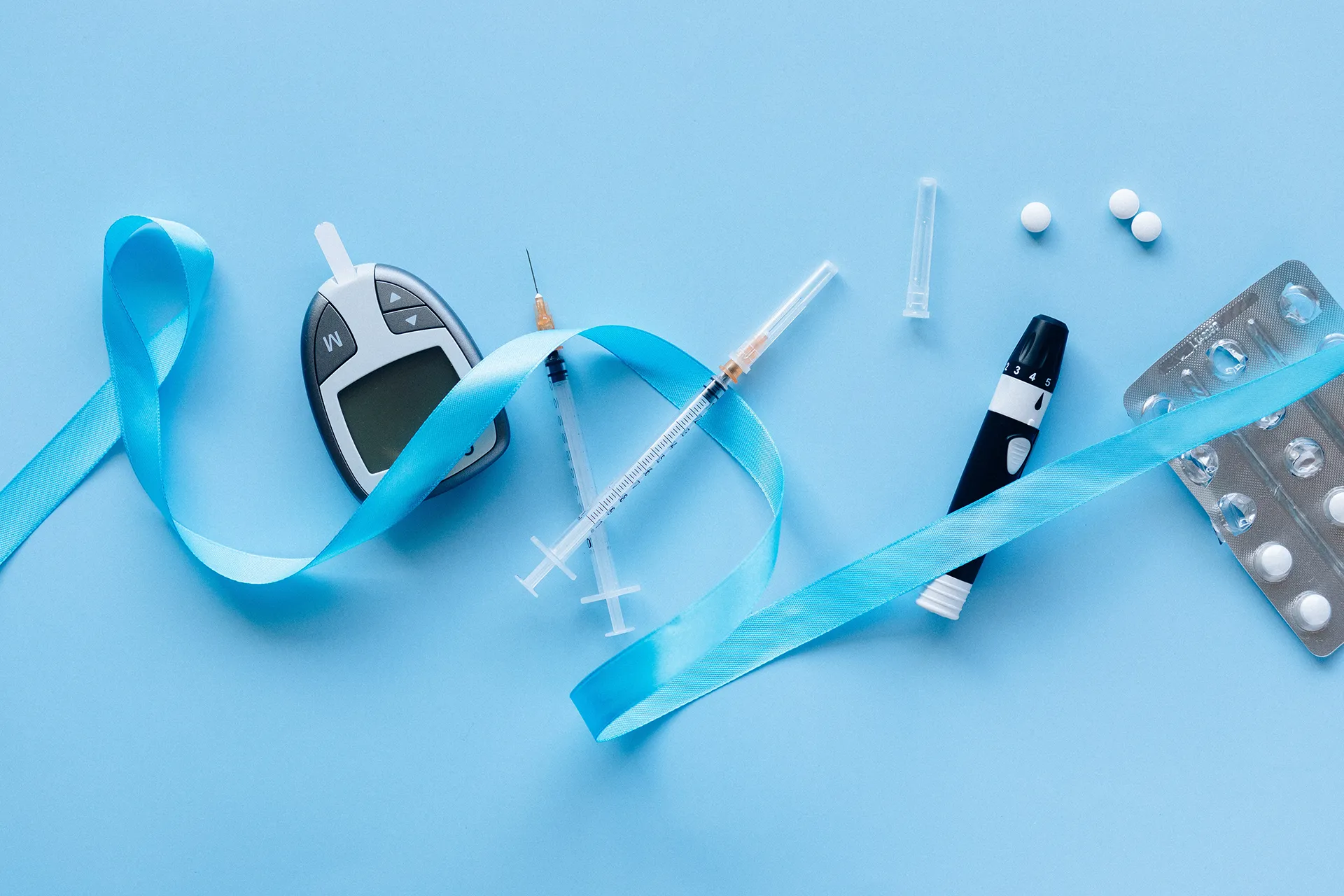 Blutzuckermessgerät, Insulinspritze und Medikamente zur Diabetesbehandlung.